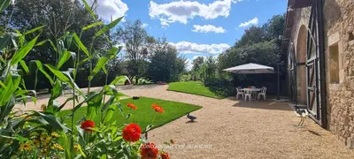 Jardin de l'établissement Gîte Le Puy Martineau piscine privée intérieure chauffée terrain arboré à 10 min du Puy du Fo