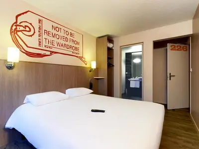 Un ou plusieurs lits dans un hébergement de l'établissement Brit Hotel Essentiel Cholet