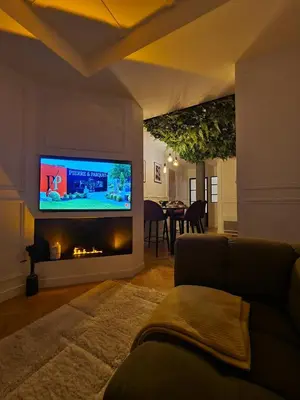 Télévision ou salle de divertissement dans l'établissement L'improbable raffiné, élégant et chaleureux
