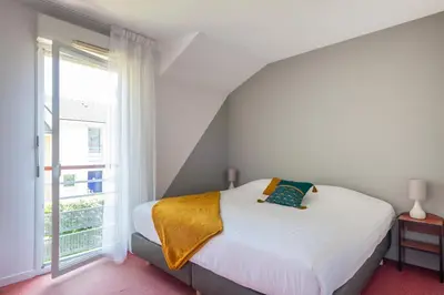 Un ou plusieurs lits dans un hébergement de l'établissement Comfort Aparthotel Nantes La Beaujoire