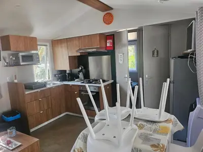Cuisine ou kitchenette dans l'établissement Mobil home 6 personnes