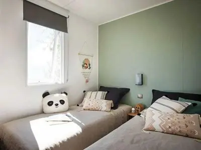 Un ou plusieurs lits dans un hébergement de l'établissement ZEcamping 4 animé animaux acceptés avec piscine couverte et bar