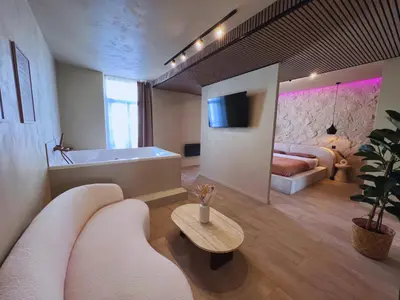 Télévision ou salle de divertissement dans l'établissement Harmony Room Suite avec Balnéo