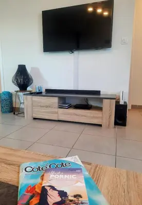 Télévision ou salle de divertissement dans l'établissement Les Merisiers - Maison moderne avec jardin