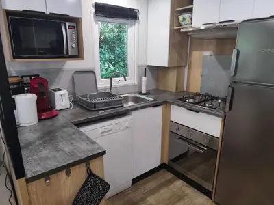 Cuisine ou kitchenette dans l'établissement Jolie Mobil Home climatisé 58