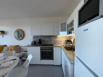 Cuisine ou kitchenette dans l'établissement Appartement cosy moderne avec terrasse et parking, à 50m de la plage - FR-1-323-569
