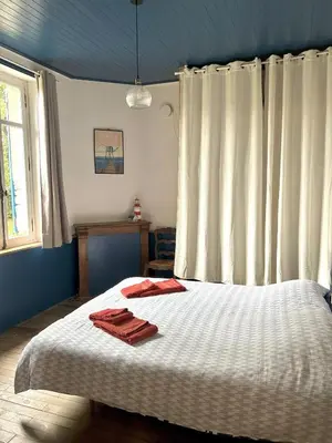 Un ou plusieurs lits dans un hébergement de l'établissement Maison avec jardin proche plage de la source