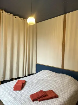 Un ou plusieurs lits dans un hébergement de l'établissement Maison avec jardin proche plage de la source