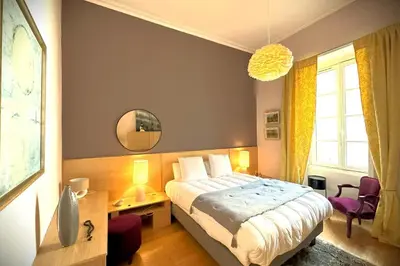 Un ou plusieurs lits dans un hébergement de l'établissement Illustre-Appartement de caractère hypercentre-Balcon
