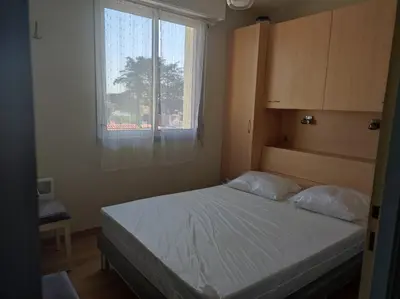 Un ou plusieurs lits dans un hébergement de l'établissement Appartement T2 450m de la plage des demoiselles, avec garage et possibilité de vélos à 950m de la rue piétonne