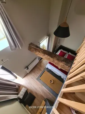 Un ou plusieurs lits dans un hébergement de l'établissement Cottage Authentique avec Mezzanine proche du Puy duFou
