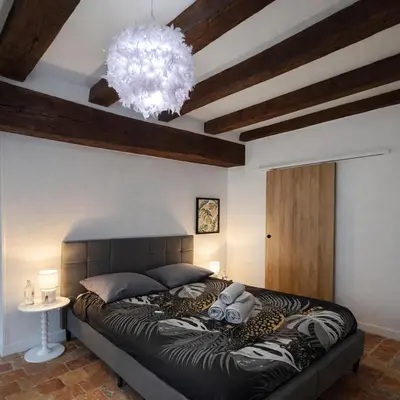 Un ou plusieurs lits dans un hébergement de l'établissement Studio de charme avec cheminée décorative