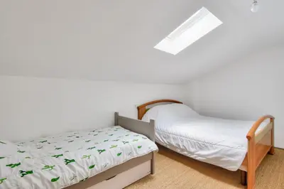 Un ou plusieurs lits dans un hébergement de l'établissement Charmante maison avec jardin à 100 m de la plage