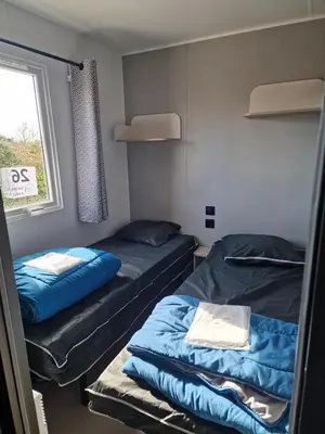 Un ou plusieurs lits dans un hébergement de l'établissement Camping Les P'tites Maisons dans la Prairie
