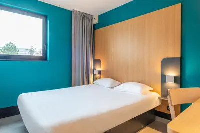Un ou plusieurs lits dans un hébergement de l'établissement B&B HOTEL Cholet Sud