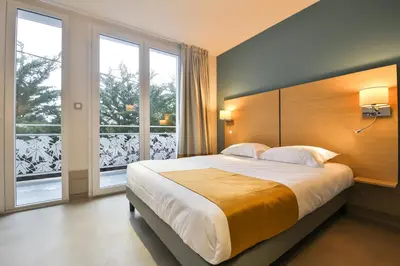Un ou plusieurs lits dans un hébergement de l'établissement Vent d'Eden Park Hôtel