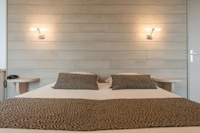 Un ou plusieurs lits dans un hébergement de l'établissement Logis Hotels - Au Poisson d'Argent - Hôtel 3 étoiles et restaurant