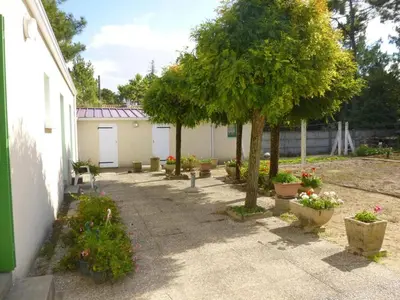 Jardin de l'établissement Maison de vacances 3 pièces, 4 couchages à 1000 m de l'océan, cadre paisible avec cour et parking - FR-1-224C-63