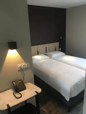 Un ou plusieurs lits dans un hébergement de l'établissement Hotel - Restaurant Les 3 Piliers