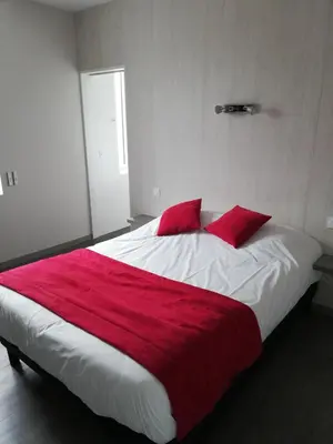 Un ou plusieurs lits dans un hébergement de l'établissement Hôtel-restaurant Les Colonnades