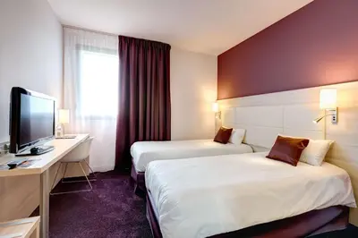 Un ou plusieurs lits dans un hébergement de l'établissement Brit Hotel Vendée Mer