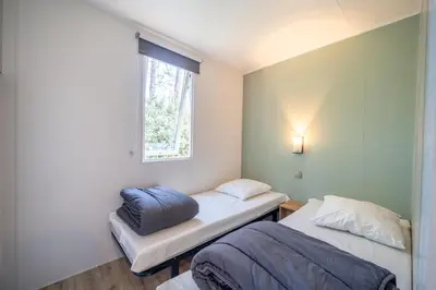 Un ou plusieurs lits dans un hébergement de l'établissement Camping Les Genêts