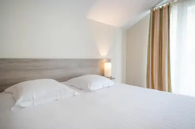 Un ou plusieurs lits dans un hébergement de l'établissement Comfort Aparthotel Saint-Nazaire Les Portes de l Ocean