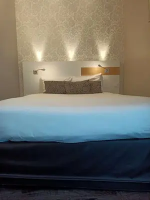 Un ou plusieurs lits dans un hébergement de l'établissement Brit Hotel Les Alizes