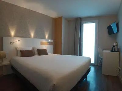 Un ou plusieurs lits dans un hébergement de l'établissement Brit Hotel Les Alizes