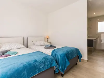 Un ou plusieurs lits dans un hébergement de l'établissement Gîte moderne avec confort, près de la mer, jardin clos, garage, WiFi, et équipements bébé - FR-1-306-1173