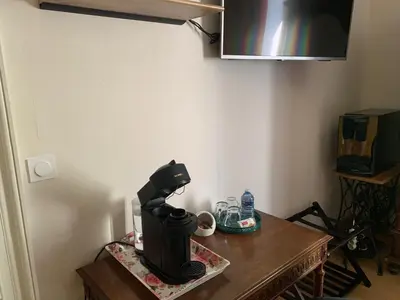 Télévision ou salle de divertissement dans l'établissement Au Fil du Temps