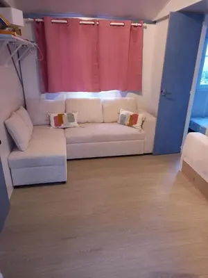 Coin salon dans l'établissement Mobil home climatisé ETANG DE BESSE