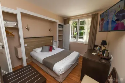 Un ou plusieurs lits dans un hébergement de l'établissement Logis Hôtel La Chaumière