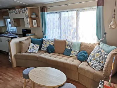 Coin salon dans l'établissement Camping les Bois Mobil home Grand Luxe 3ch 2sdb