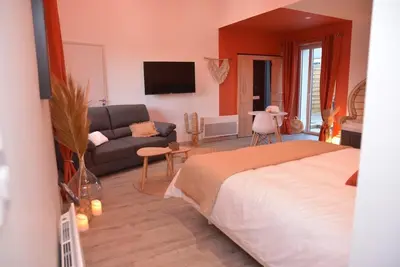 Télévision ou salle de divertissement dans l'établissement L'Evasion chambre DUNE avec sauna et spa privatifs