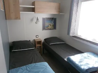 Un ou plusieurs lits dans un hébergement de l'établissement Mobilhome 3 chambres tout confort, proche de la plage