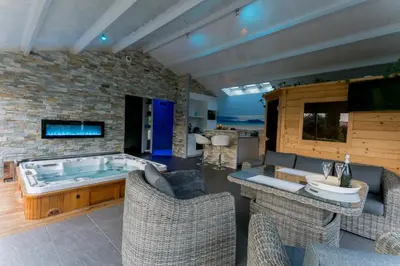 Télévision ou salle de divertissement dans l'établissement Charmante maison avec spa, sauna et jardin privatif